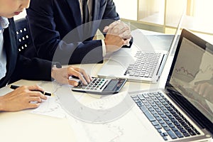 business man and woman sit at ther table looking at computer laptop photo
