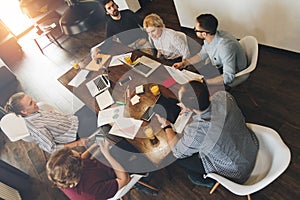 Business man and woman sitting around table at office and working with laptops and tablet. Coworking people discussing new plan d