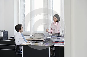 Business man and woman talking in office smiling