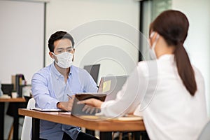 Business man and woman wearing face mask meeting and working together for discussion and brainstroming