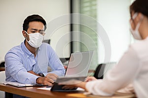 Business man and woman wearing face mask meeting and working together for discussion and brainstroming