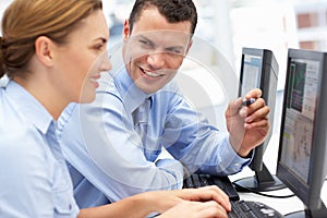 Business man and woman working on computers