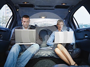 Business Man And Woman Working With Laptop In Limousine