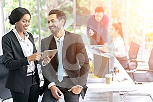 Business Man and Woman Working Together with Colleagues sitting in the background