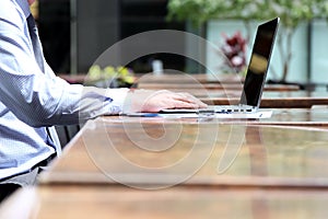 Business man working and analyzing financial figures on a graphs on a laptop outside