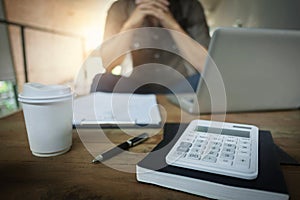 Business man working at a cafe with laptop, finance documents and calculator on the table, selective focus