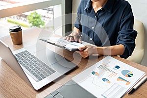 Business man working with graph data in laptop and documents on his desk at office