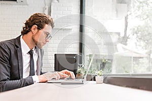 Business man working hard with laptop on desk in office near window. Business and Success concept. People and Occupation concept.
