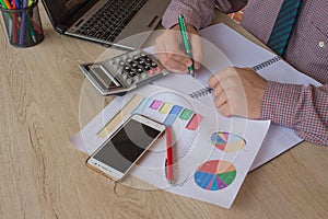 A business man working in home office table plan for business market analysis. Man hand with calculator at workplace offic