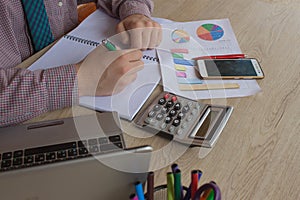 A business man working in home office table plan for business market analysis. Man hand with calculator at workplace offic