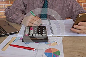 A business man working in home office table plan for business market analysis. Man hand with calculator at workplace offic