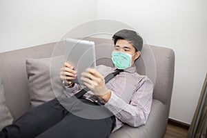Business man working from home wearing protective mask.  Cleaning his hands with sanitizer gel quarantine for coronavirus