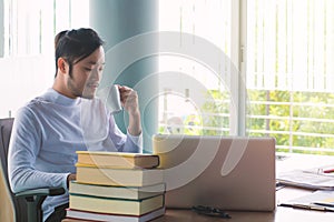 Business man working with laptop computer and documents on his desk at office