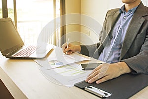 Business man working with laptop and documents on wood table