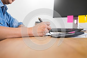 Business man working on a laptop tablet and graph data documents on his desk in home office