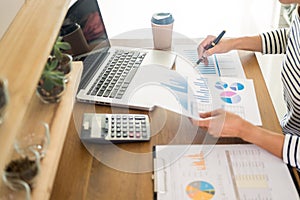 Business man working on a laptop tablet and graph data documents on his desk in home office