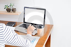 Business man working on a laptop tablet and graph data documents on his desk in home office