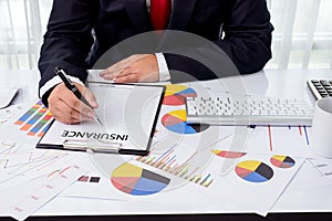 Business man working at office with desktop computer and documents on his desk