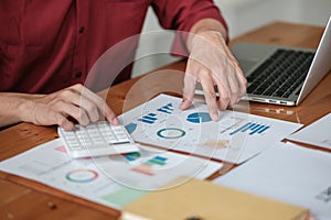 Business man working at office with digital tablet and laptop computer calculating financial report graph data documents