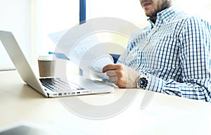 Business man working at office with laptop and documents on his desk