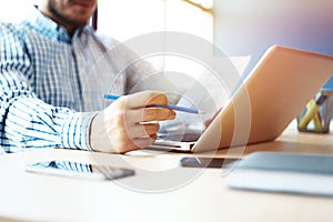 Business man working at office with laptop and documents on his desk photo