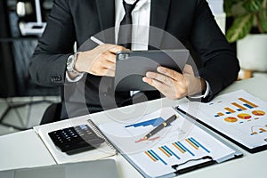 Business man working at office with laptop and documents on his desk, financial adviser analyzing data