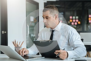 Business man working at office with laptop and documents on his desk, financial adviser analyzing data