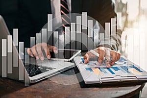 Business man working at office with laptop and tablet on documents on his desk, financial adviser analyzing data