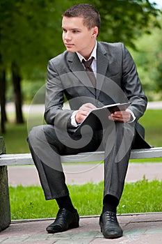 Business man working with papers at park. Student