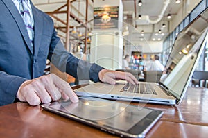 Business man working using Ipad while working with laptop photo