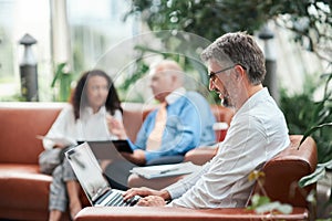 business man works using a laptop in the office lobby.