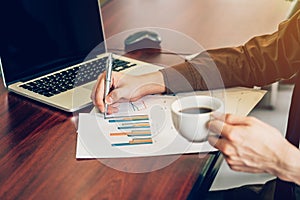 Business man writing paper sheet on wood table in office.