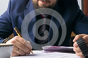 Business man writing a treaty or contract at the table and working on documents in the office,business concept.