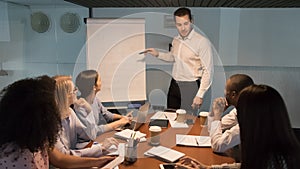 Business manager coach speaker giving corporate presentation pointing at flipchart