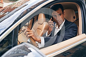 Business manager communicating on phone from car