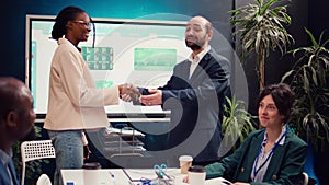 Business manager does handshake with a new employee during a briefing meeting