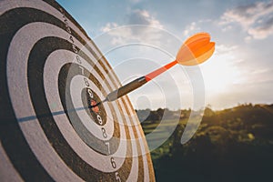 Business marketing as concept. Red dart arrow hitting in the target center of dartboard Target hit in the center
