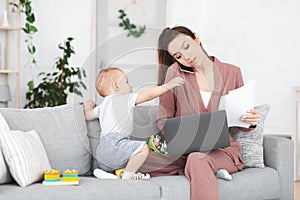 Business And Maternity. Annoyed mom trying to work while toddler distracting her