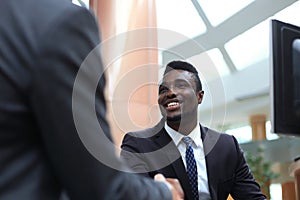 Business meeting. African American businessman shaking hands with caucasian businessman.