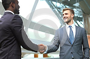 Business meeting. African American businessman shaking hands with caucasian businessman