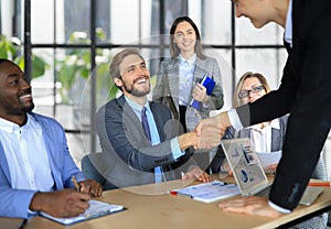 Business meeting associates shaking hands in office.