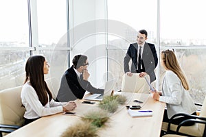Business meeting. Business people in formalwear discussing something while sitting together at the table