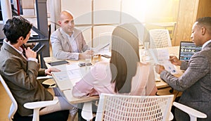 Business meeting between four professional entrepreneurial executives indoors