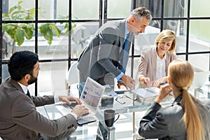 Business meeting - manager discussing work with his colleagues.