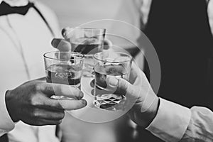 Business meeting. Men hold glasses of whiskey. Men`s Party. Hand with a drink of alcohol