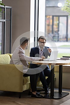Business meeting in modern office of two businessmen with laptop