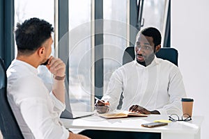 Business meeting in office. Employment interview. Two business partners are talking while sitting at the table.