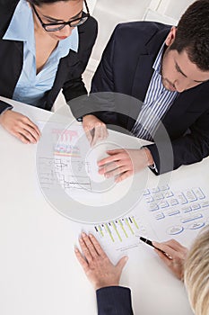 Business meeting. Three people sitting at the table in an office