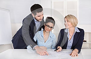 Business meeting. Three people sitting at the table in an office