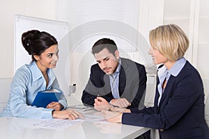 Business meeting. Three people sitting at the table in an office